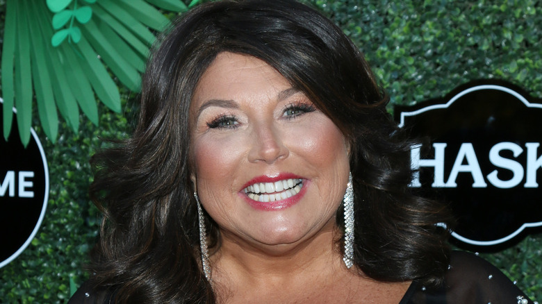 Abby Lee Miller souriante avec des boucles d'oreilles lors d'un événement