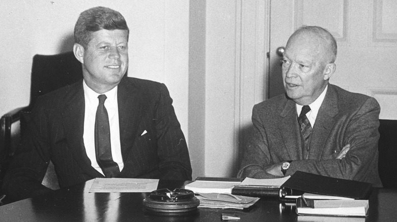 JFK et Ike souriant en costume autour d'une table