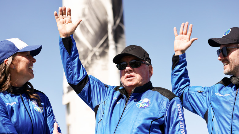 William Shatner en tenue Blue Origin faisant signe