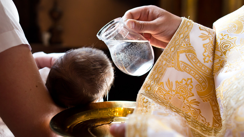 un prêtre baptisant un nourrisson