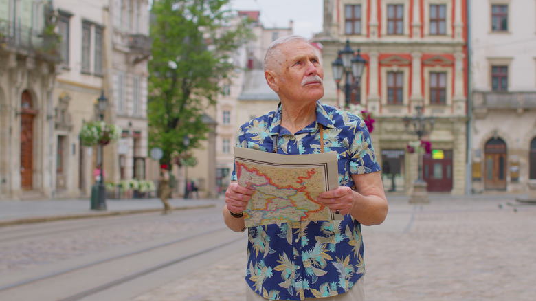 Homme cherchant son chemin avec une carte papier