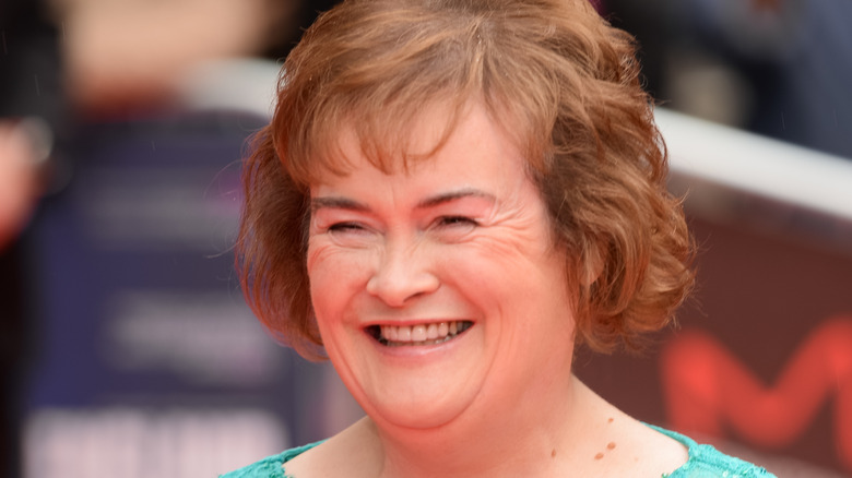 Susan Boyle souriante dans une robe turquoise