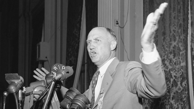 Strom Thurmond arms raised suit talking mics