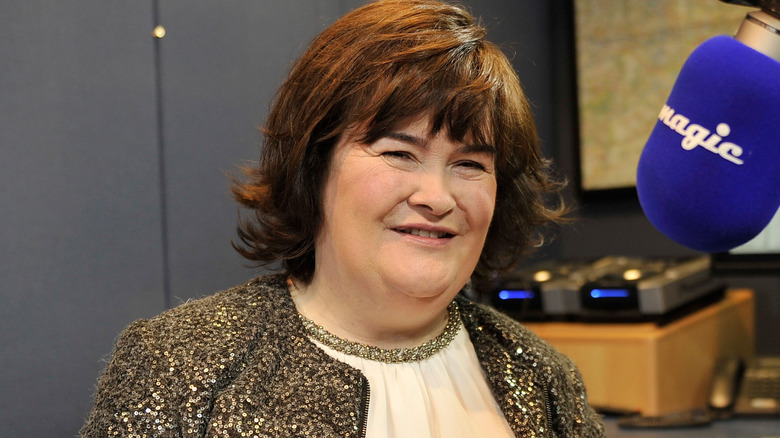 Susan Boyle souriante devant un microphone radio