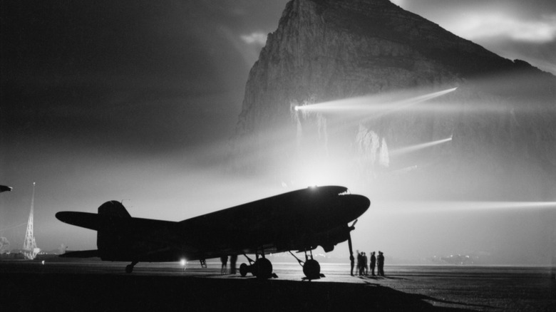 Douglas DC-3 contre le rocher de Gibraltar, silhouetté par des projecteurs, 1940 à 1945.