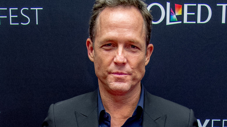 Dean Winters souriant en costume