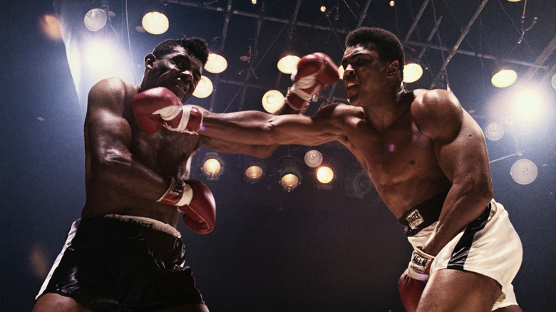 Muhammad Ali punching another boxer in the chin