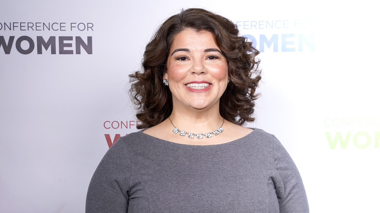 Celeste Headlee en robe grise souriant pour une photo