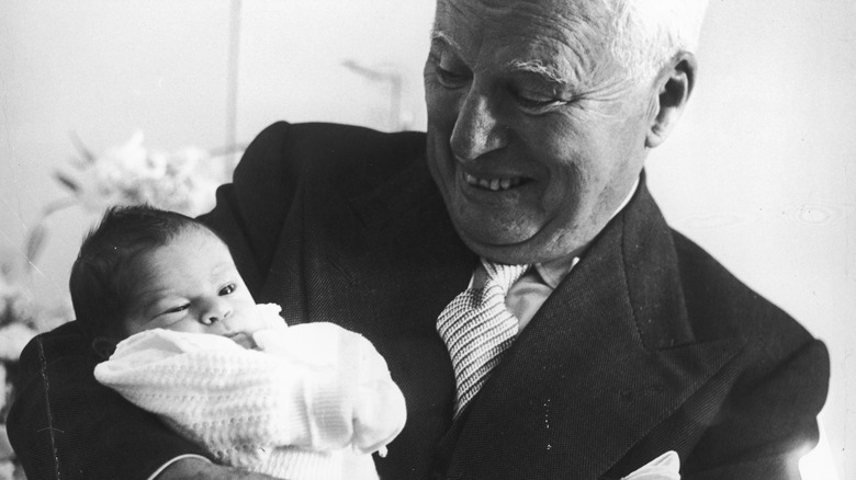 Charlie Chaplin holds a newborn Christopher