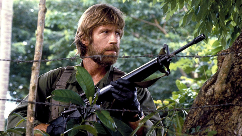 Chuck Norris portant un fusil