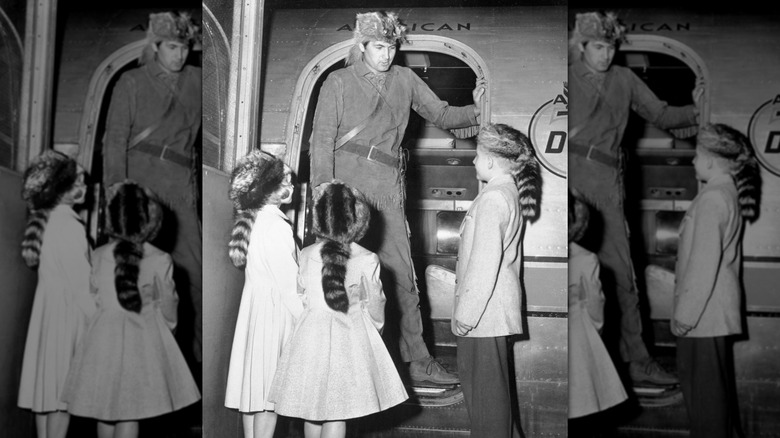 Fess Parker saluant de jeunes fans déguisés en Davy Crockett