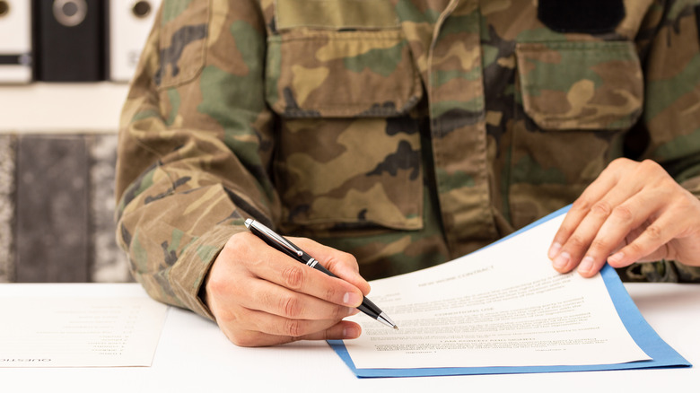 Personnel militaire signant un document