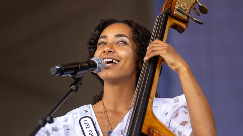 Esperanza Spalding souriant en chantant et jouant de la contrebasse