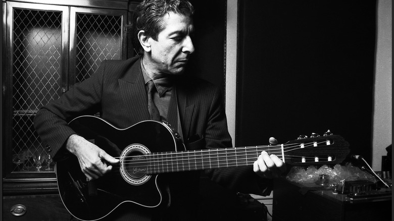 Leonard Cohen jouant de la guitare dans les années 80