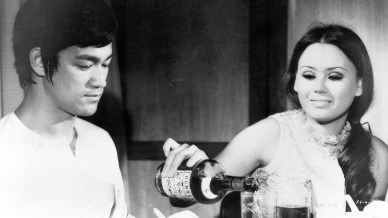 Une femme versant une boisson à Bruce Lee