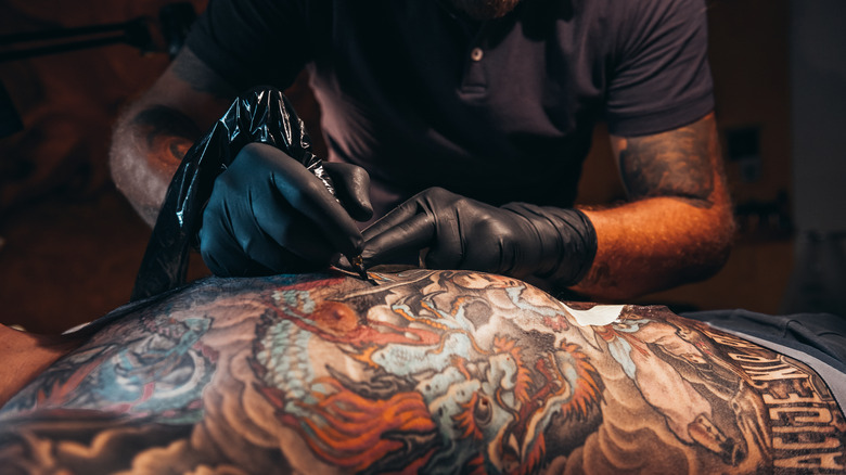 Homme se faisant tatouer dans le dos