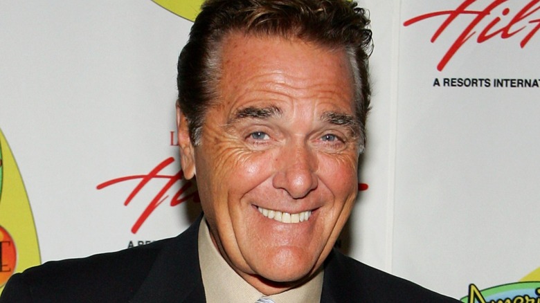 Chuck Woolery souriant avec les sourcils levés