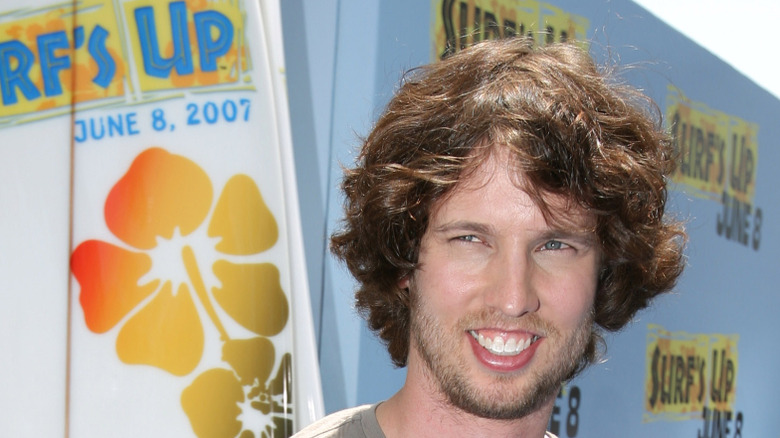 Jon Heder avec de grands cheveux souriant à la première de Surf's Up