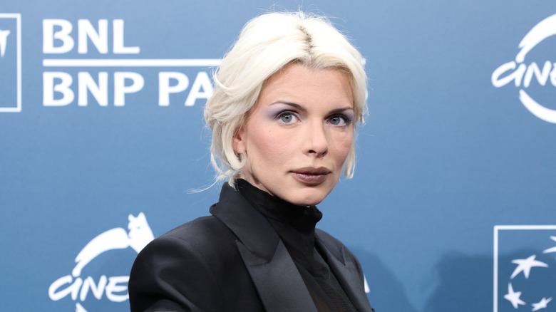 Julia Fox, cheveux blonds, portant du noir et posant pour une photo