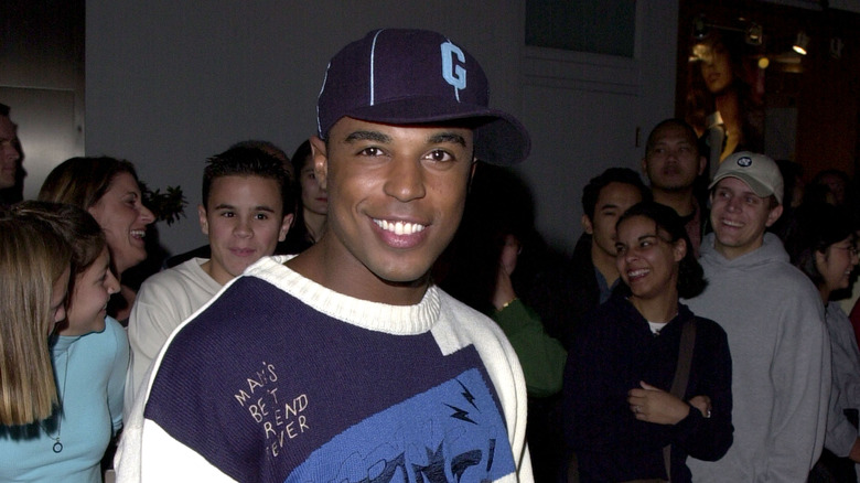 Merlin Santana souriant avec un chapeau à une fête