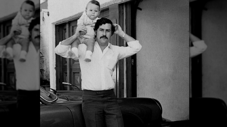 Pablo Escobar avec un enfant sur ses épaules près d'une voiture