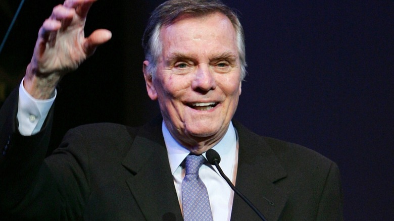 Peter Marshall souriant et faisant un signe de la main