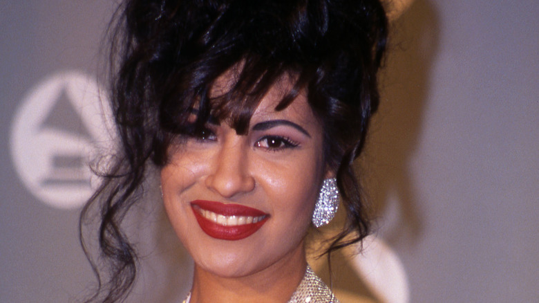 Selena souriant avec des boucles d'oreilles en diamant lors d'un événement