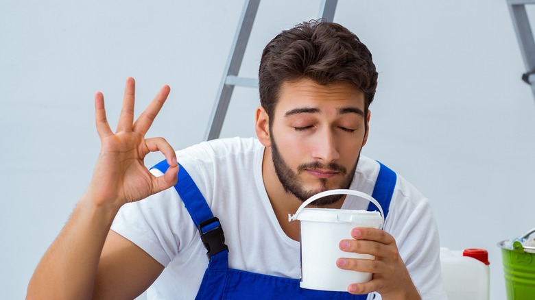 Guy donnant le signe 'ok' en sentant de la colle
