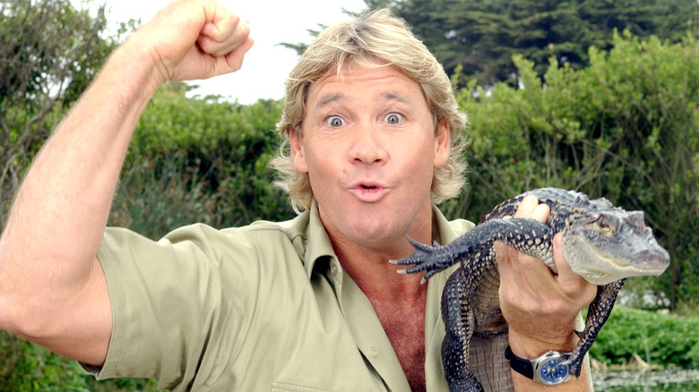 Steve Irwin levant le poing tenant un petit crocodile