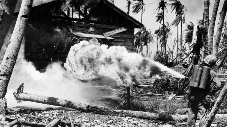 Un marine utilise un lance-flammes pour détruire un bâtiment pendant la Seconde Guerre mondiale