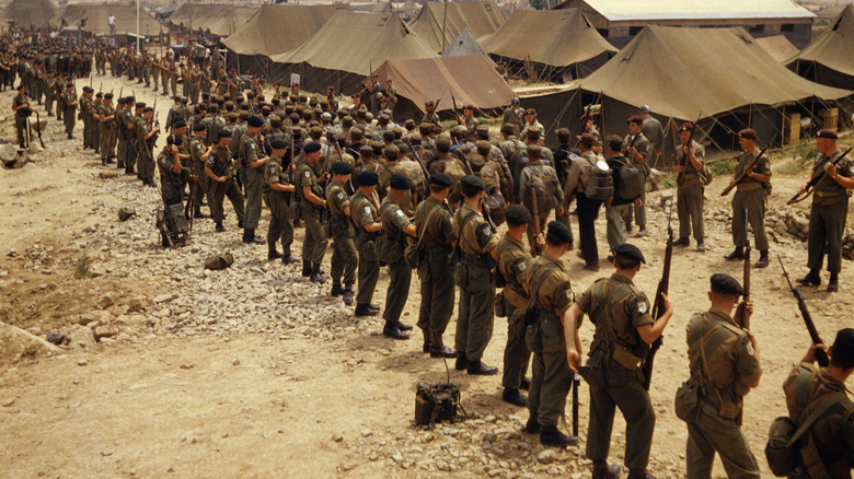 UN troops watching prisoners march at Koje Island prison camp