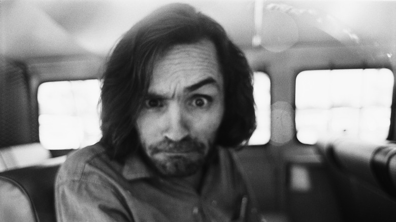 Charles Manson dans une voiture, levant le sourcil