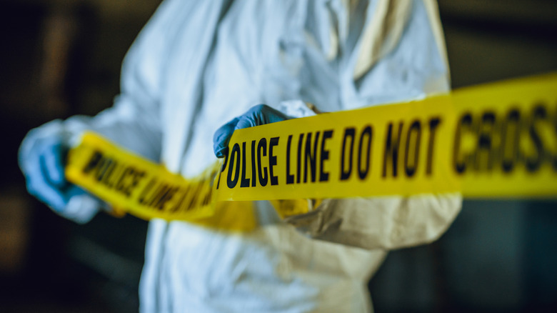 crime scene investigator holding police line