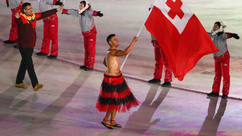 Pita Taufatofua portant le drapeau