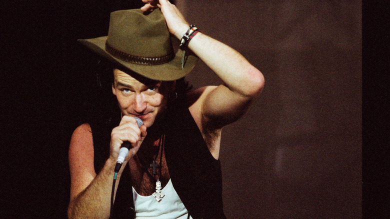 Bono wearing a hat while performing on stage with U2