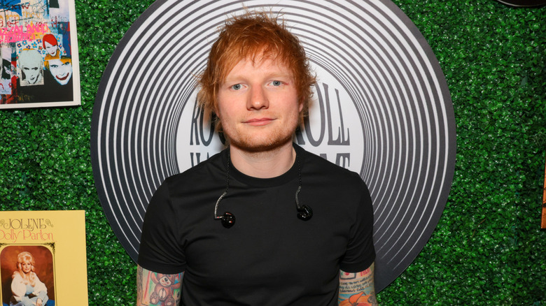 Ed Sheeran posant devant un fond feuillu