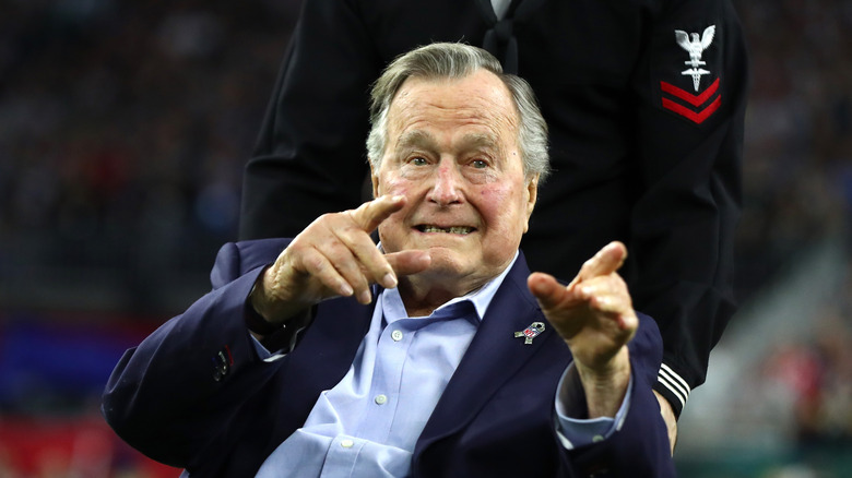 Un George H.W. Bush âgé, souriant et pointant