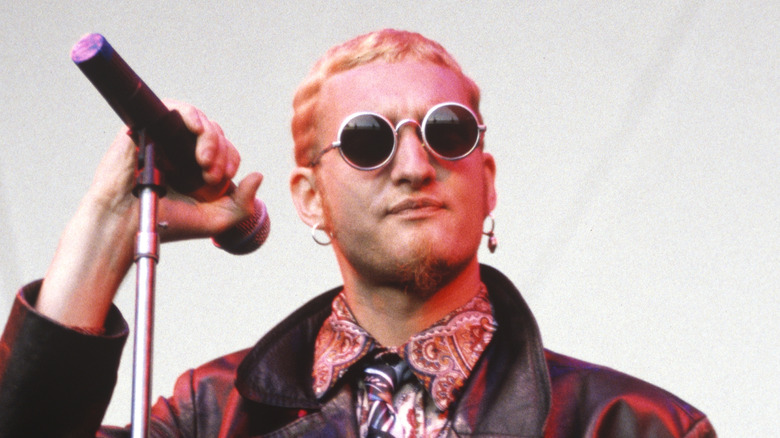 layne staley on stage with blond hair, round glasses, paisley clothes