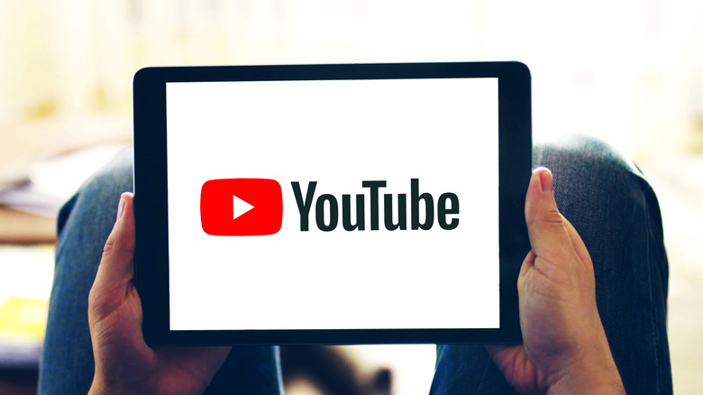 Holding tablet with YouTube logo