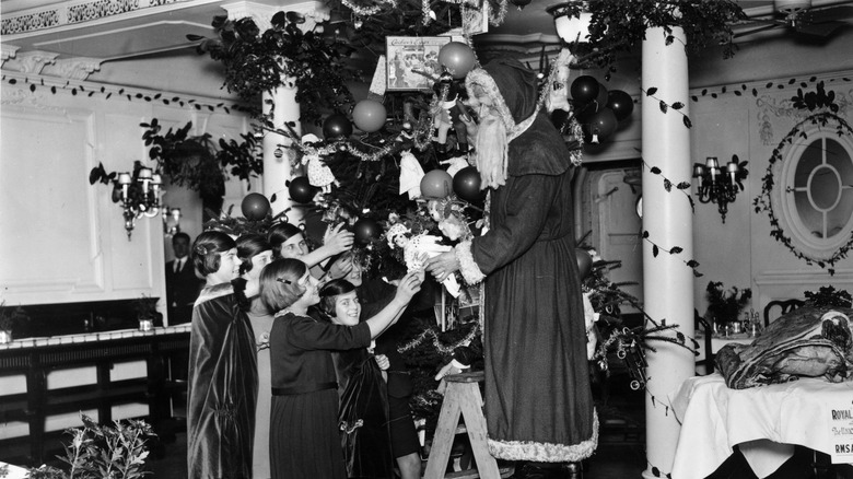 Père Noël distribuant des cadeaux aux enfants