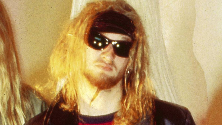 Layne Staley avec des lunettes de soleil et de longs cheveux, grimpant en 1990