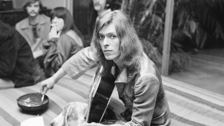 David Bowie playing guitar