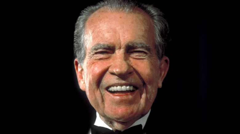 Richard Nixon en costume avec un grand sourire