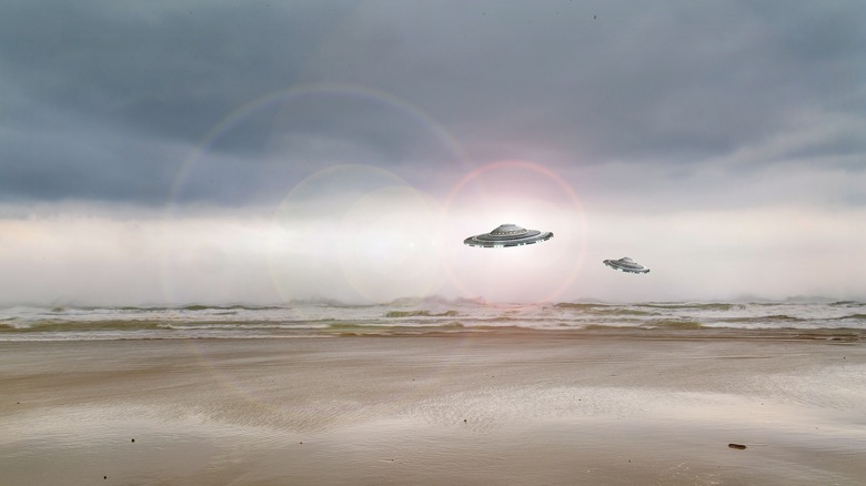 Illustration of UFOs flying over beach