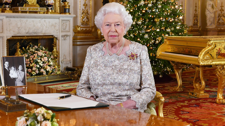 Reine Elizabeth II assise à un bureau