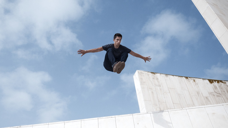 man jumping off building feet first