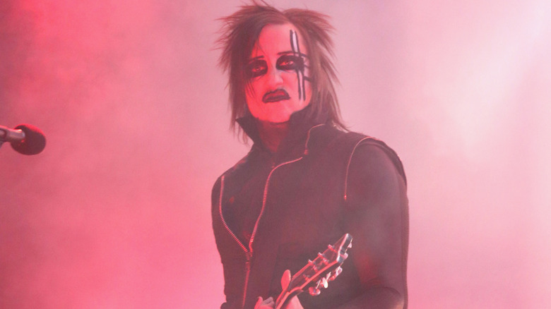 Paul Wiley jouant de la guitare pour Marilyn Manson sur scène avec du maquillage