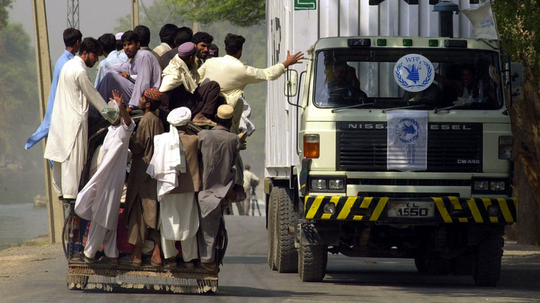 Des réfugiés passent à côté d'un camion d'aide alimentaire en Afghanistan