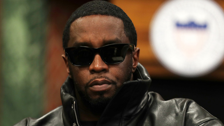 Sean Diddy Combs pointant du doigt en costume gris